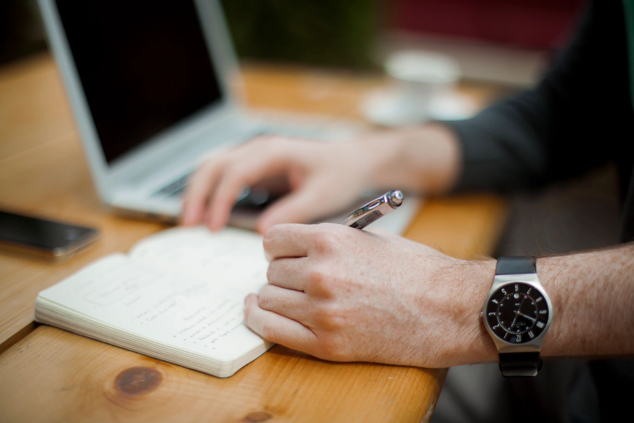 man writing in notebook 